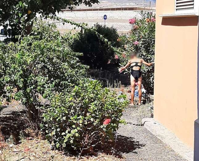 Imagen captada por vecinos de la zona de la mujer en bañador refrescándose con una garrafa de agua/TA.